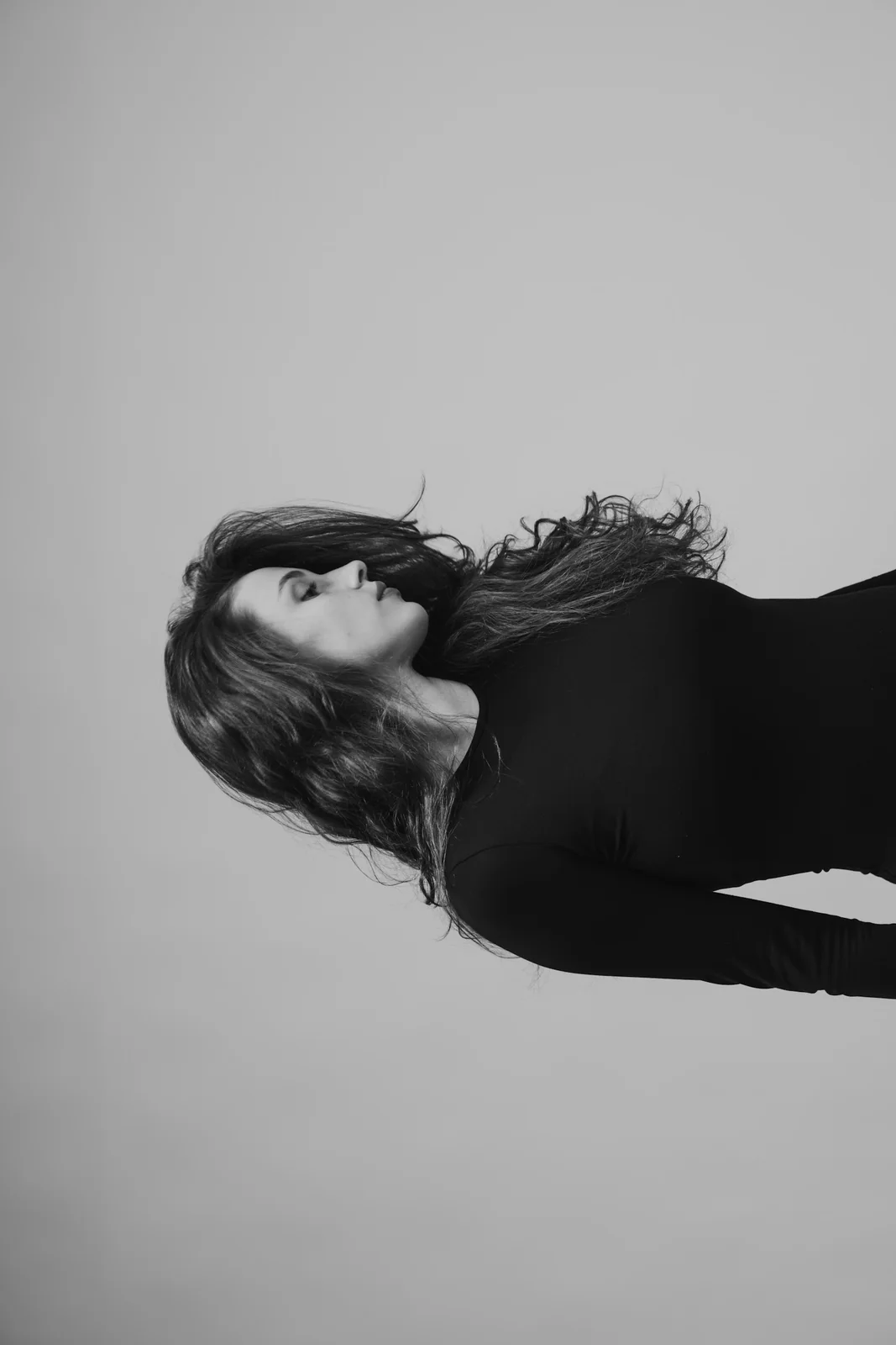 A monochrome portrait showing softly styled hair