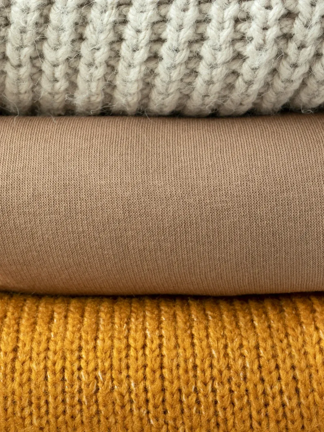 Folded knit textiles in warm neutral colours